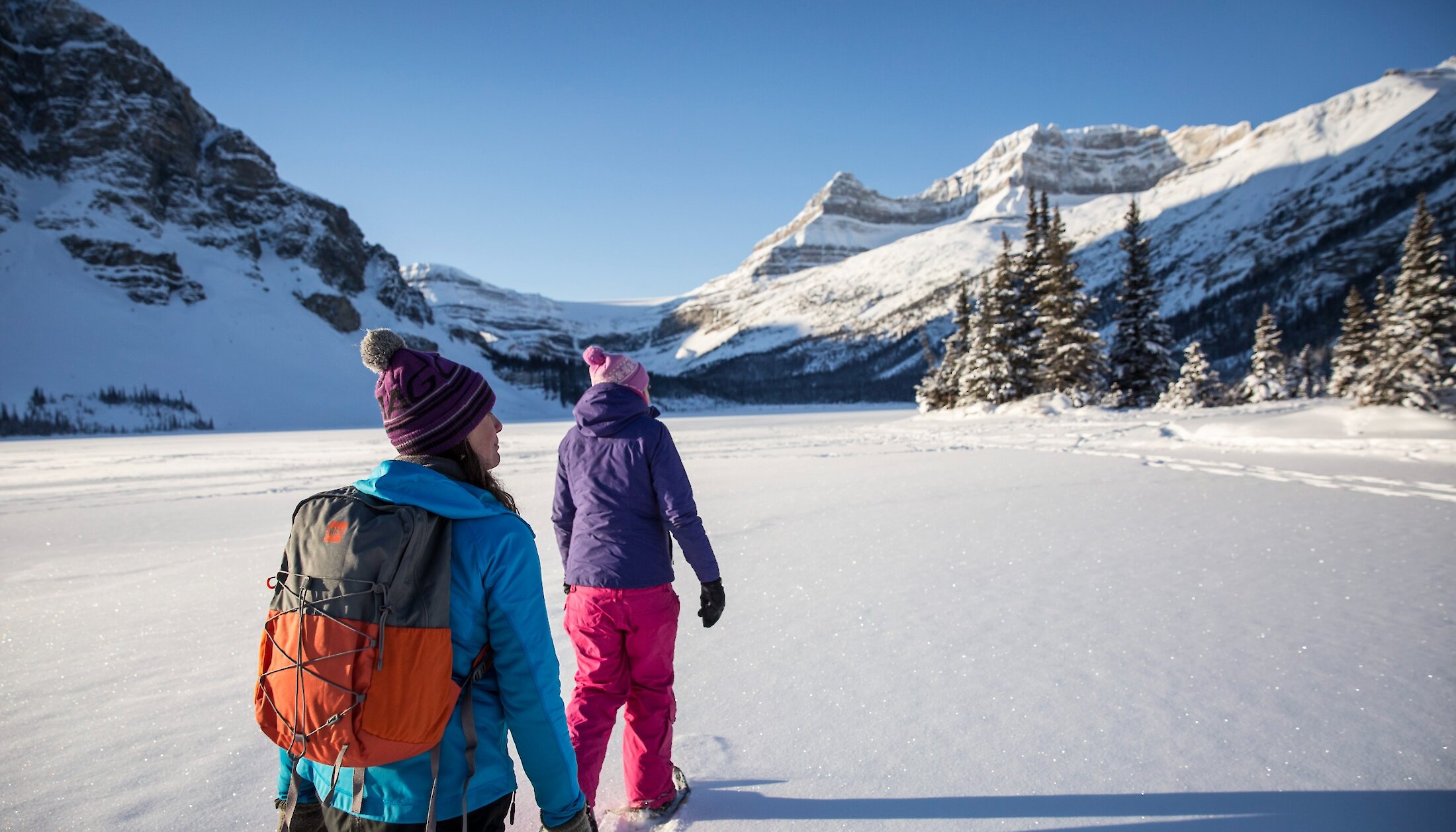 Two people snowshoeing on Bow Lake on the Icefield Parkway