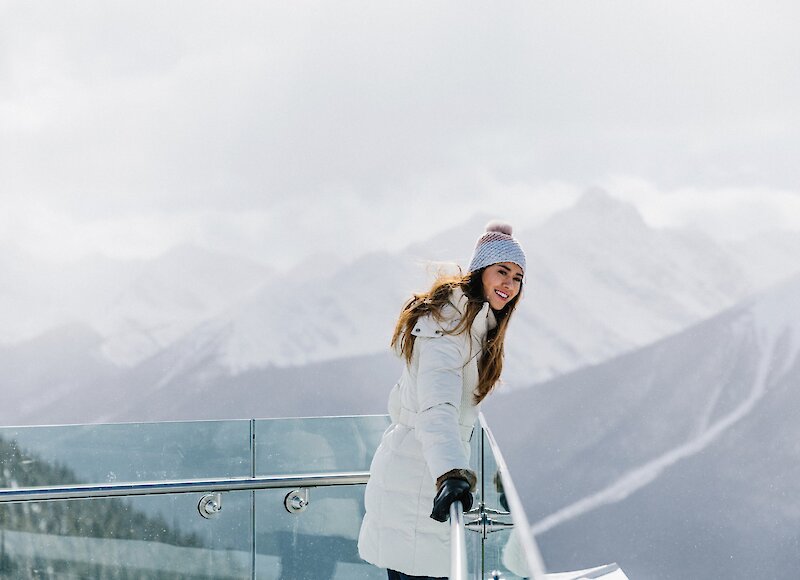 Woman admiring the views from the top of Banff Gondola in winter