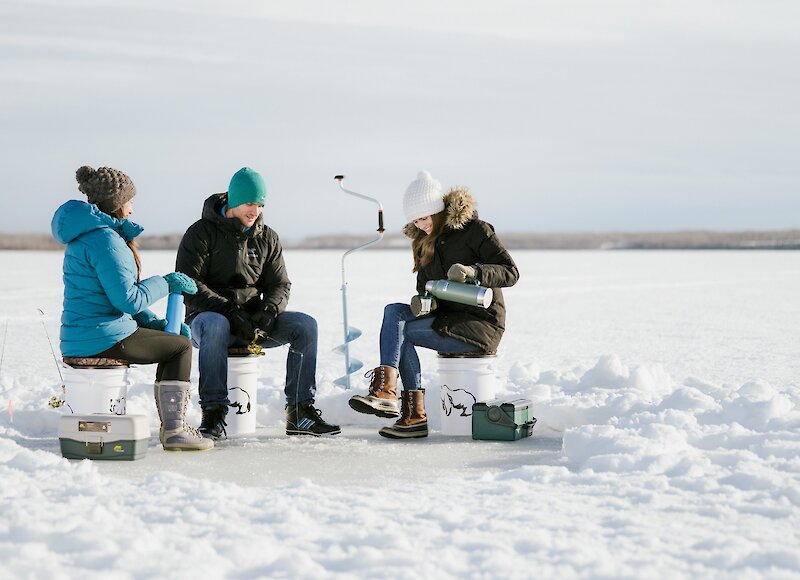 Group of friends enjoying ice fishing