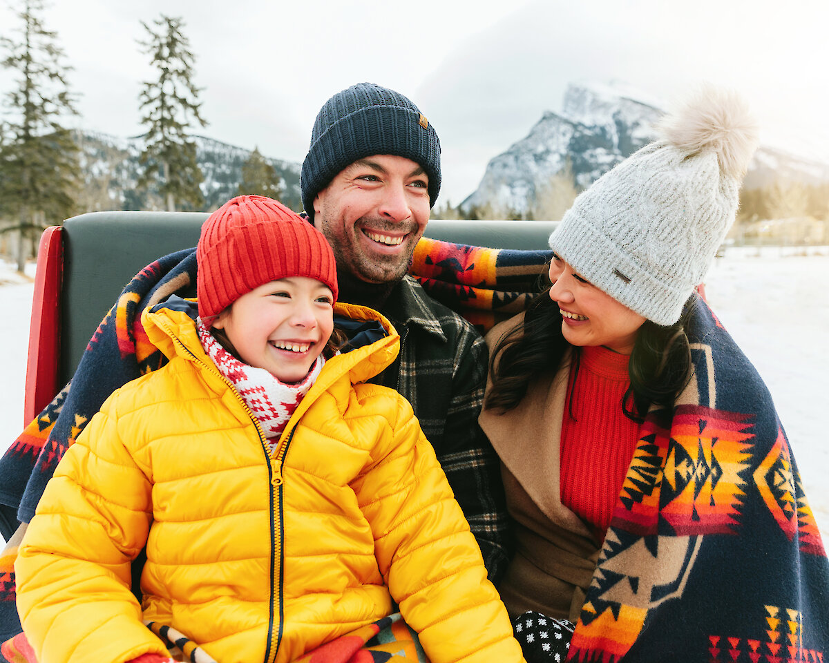 A family enjoying a private sleigh ride through the Banff meadows
