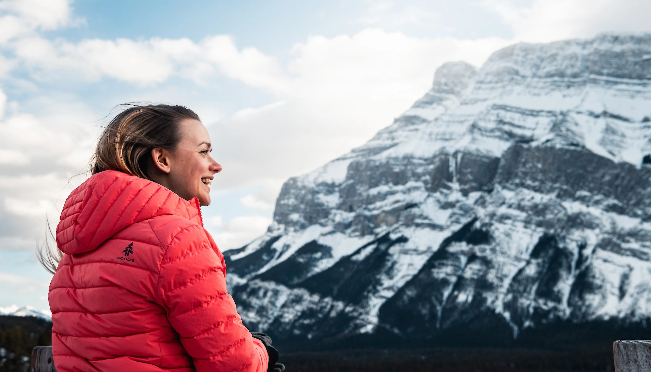 A woman smiling and admiring the view of Mount Rundle in Banff