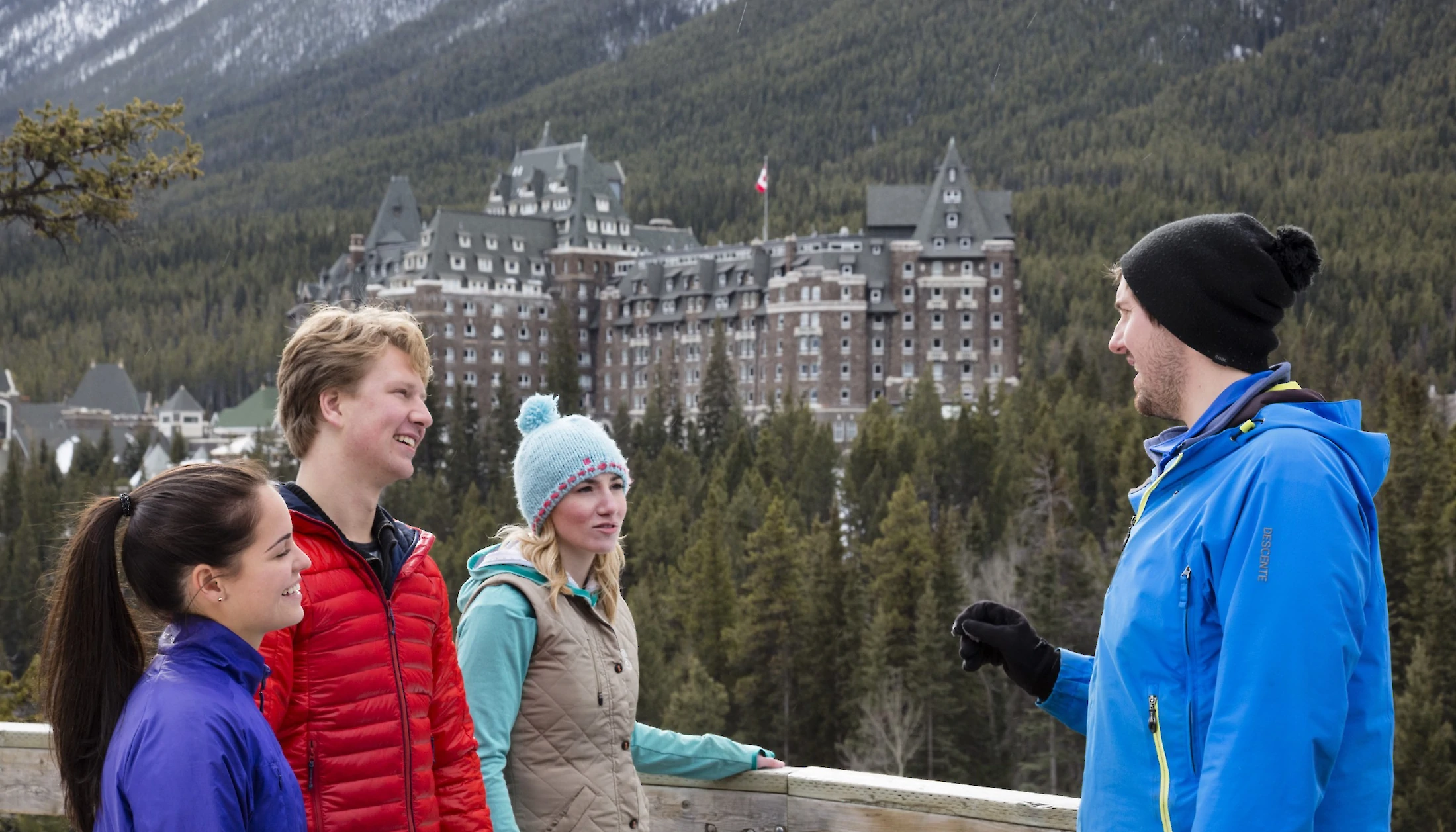 A group of guests and a guide standing and chatting at Surprise Corner Viewpoint in Banff