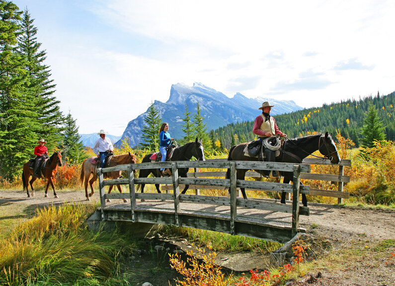 Riding across a bridge on the Bow River Horseback ride