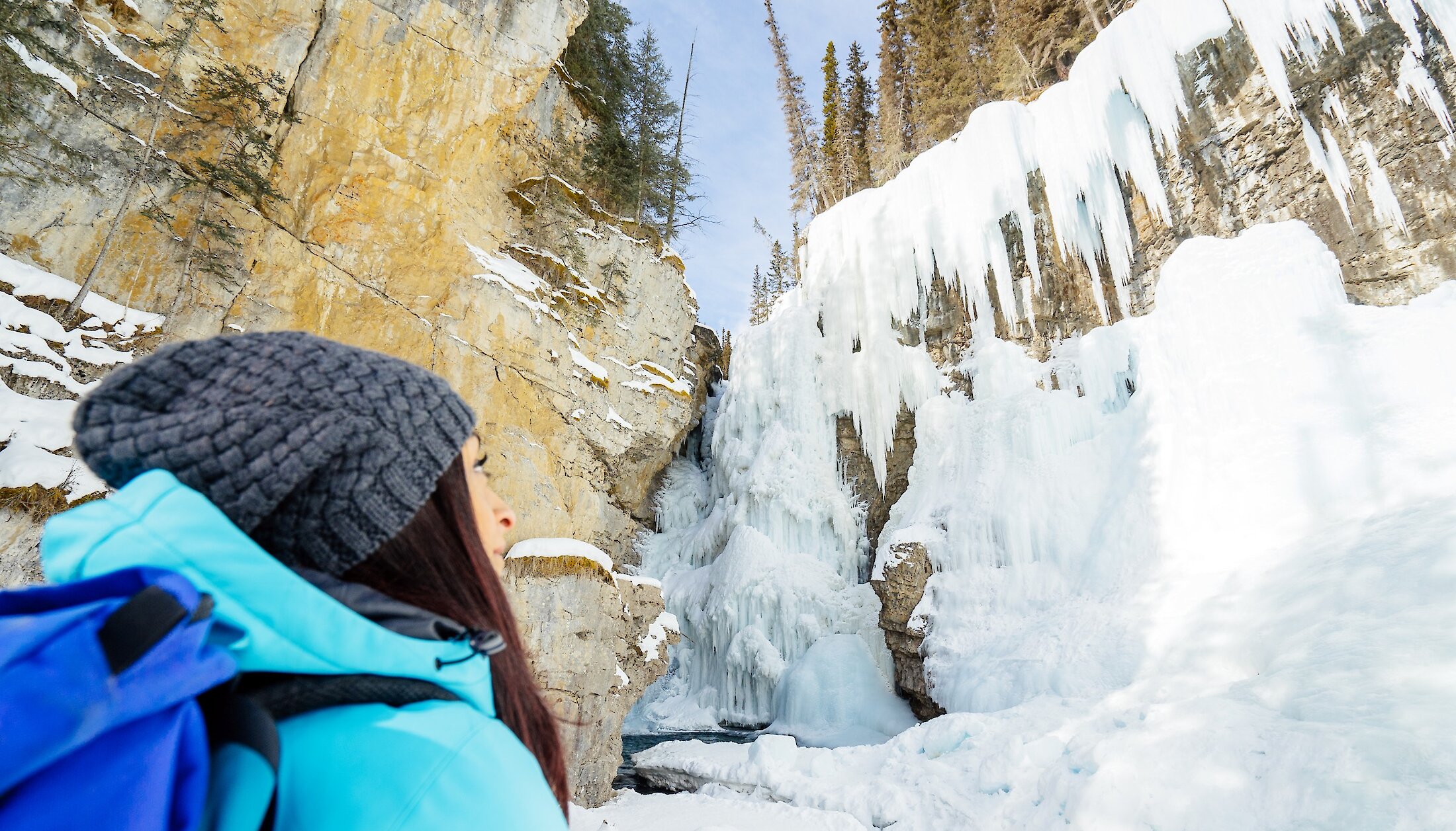 lady gazing at the frozen ice falls at Johnston Canyon