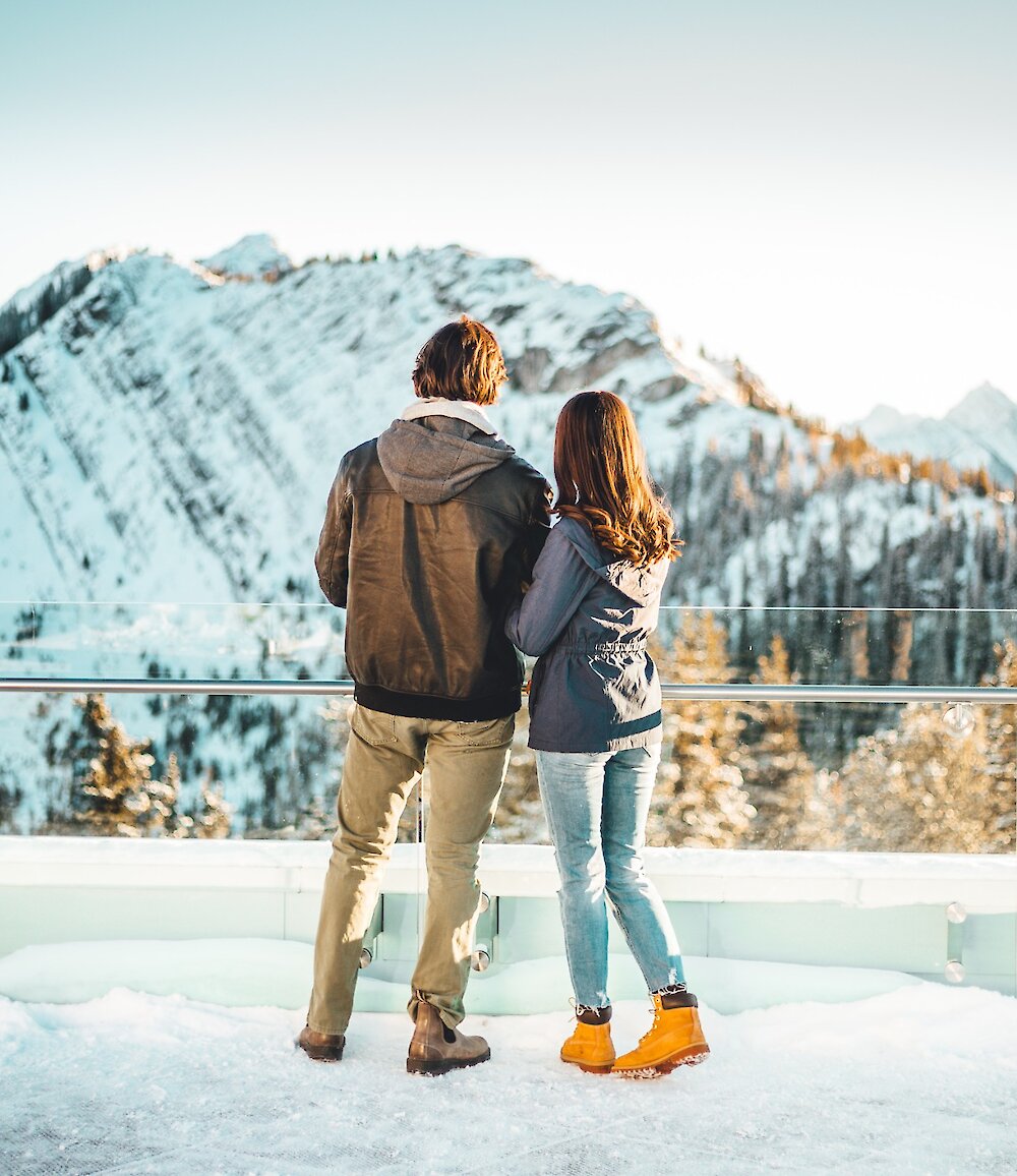 A couple soaking in the views from the top of the Banff Gondola in winter