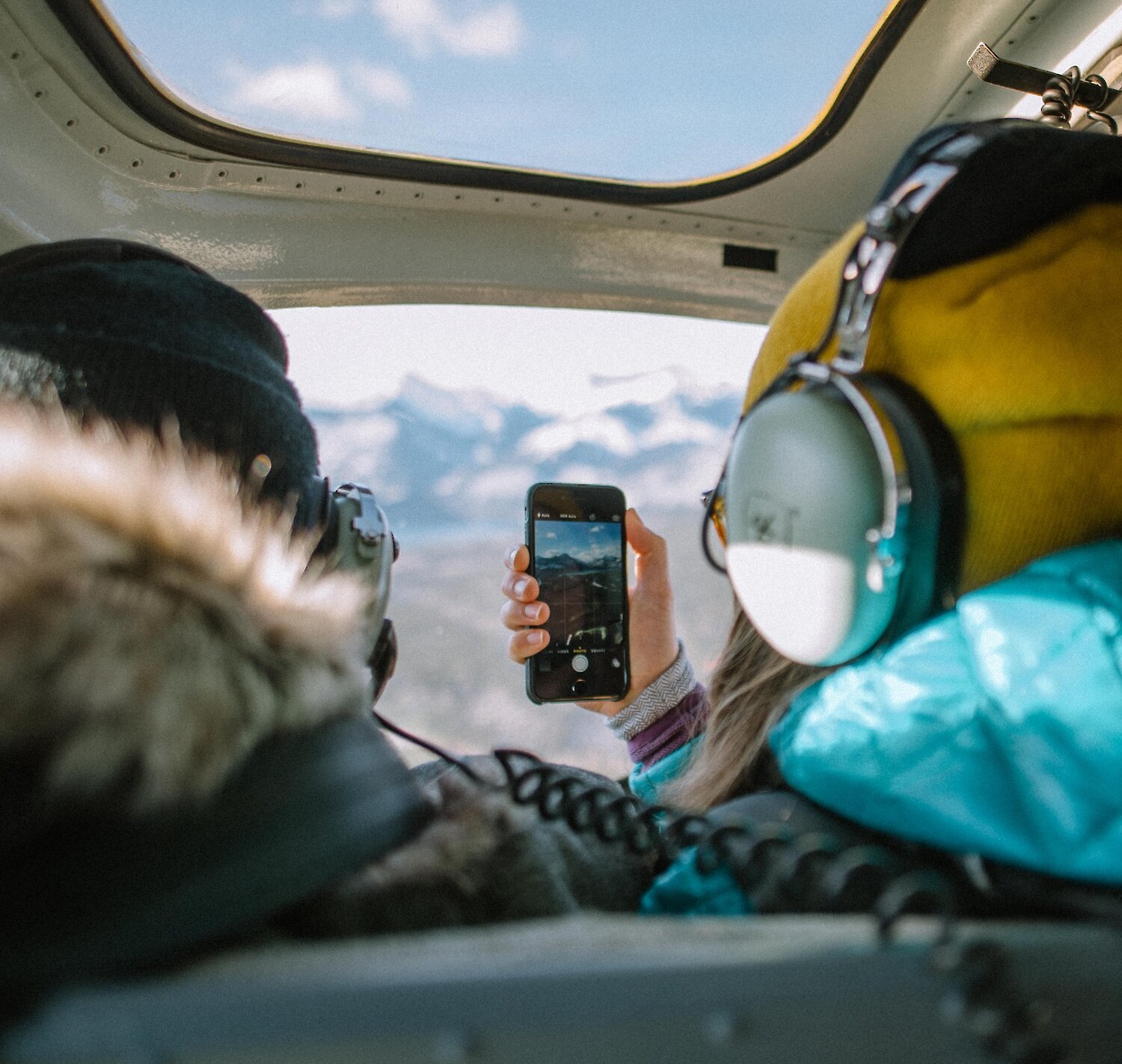A couple taking photos during a winter helicopter flight