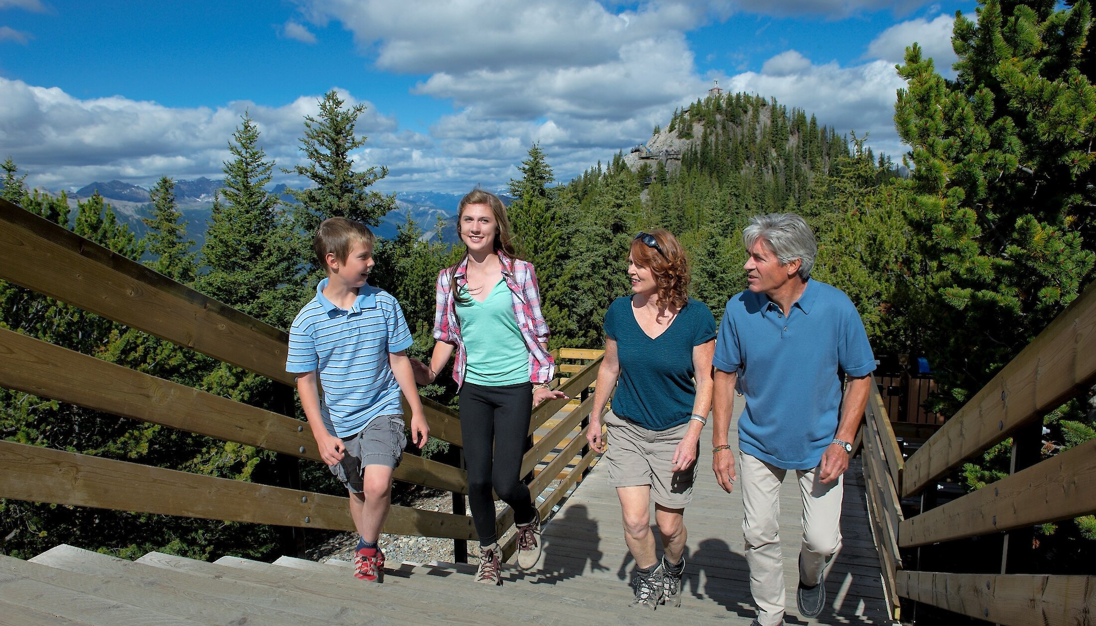 A family walking up the steps of the Banff Gondola Boardwalk in summer