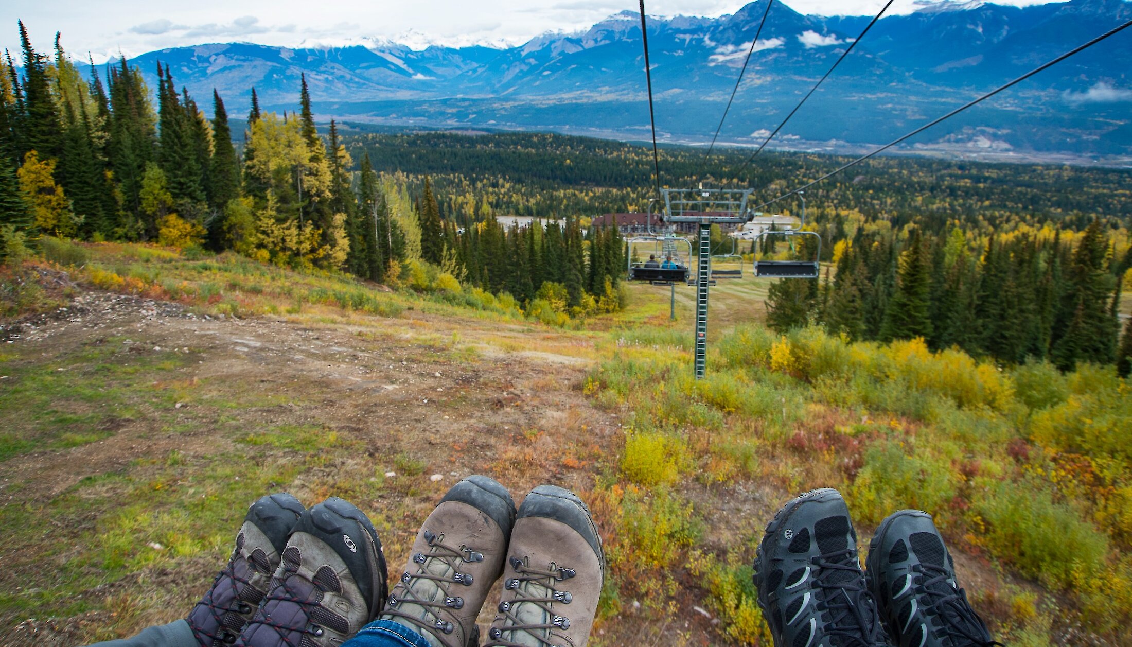 Peoples feet dangling off the chairlift at Kicking Horse Mountain Resort