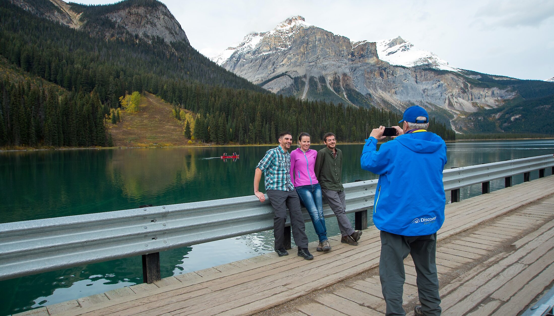 A guide taking a photo of some people at Emerald Lake
