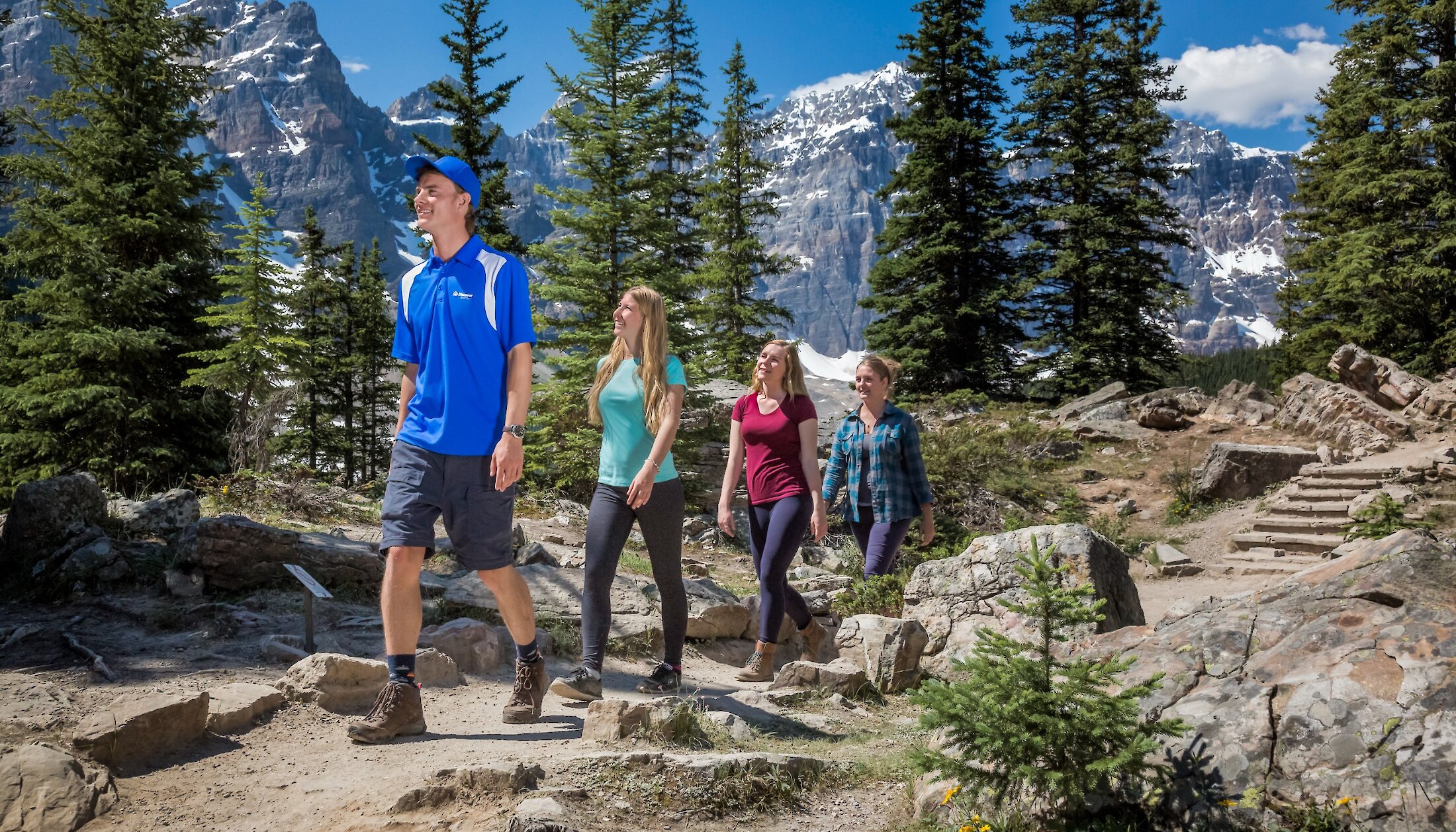 A guide leading guests up the rockpile to the viewpoint at Moraine Lake