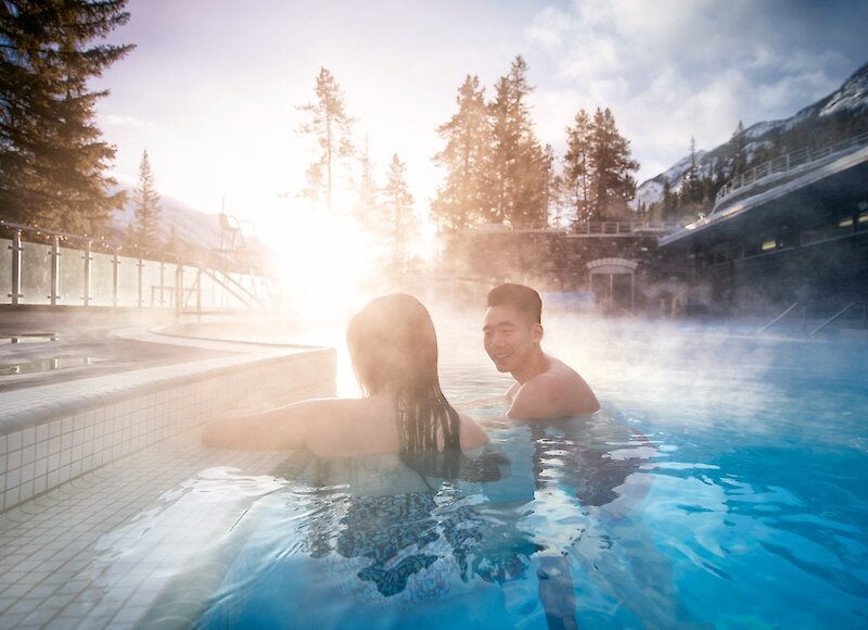 A couple in the Banff Upper Hot Springs enjoying the hot mineral water and mountain views