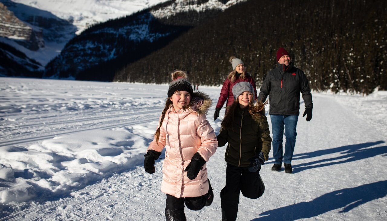 Family enjoying a walk around Lake Louise in winter