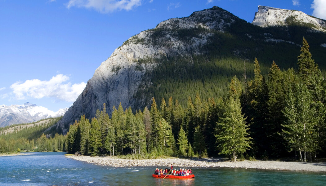 Floating past Rundle Mountain on raft down the Bow River in Banff
