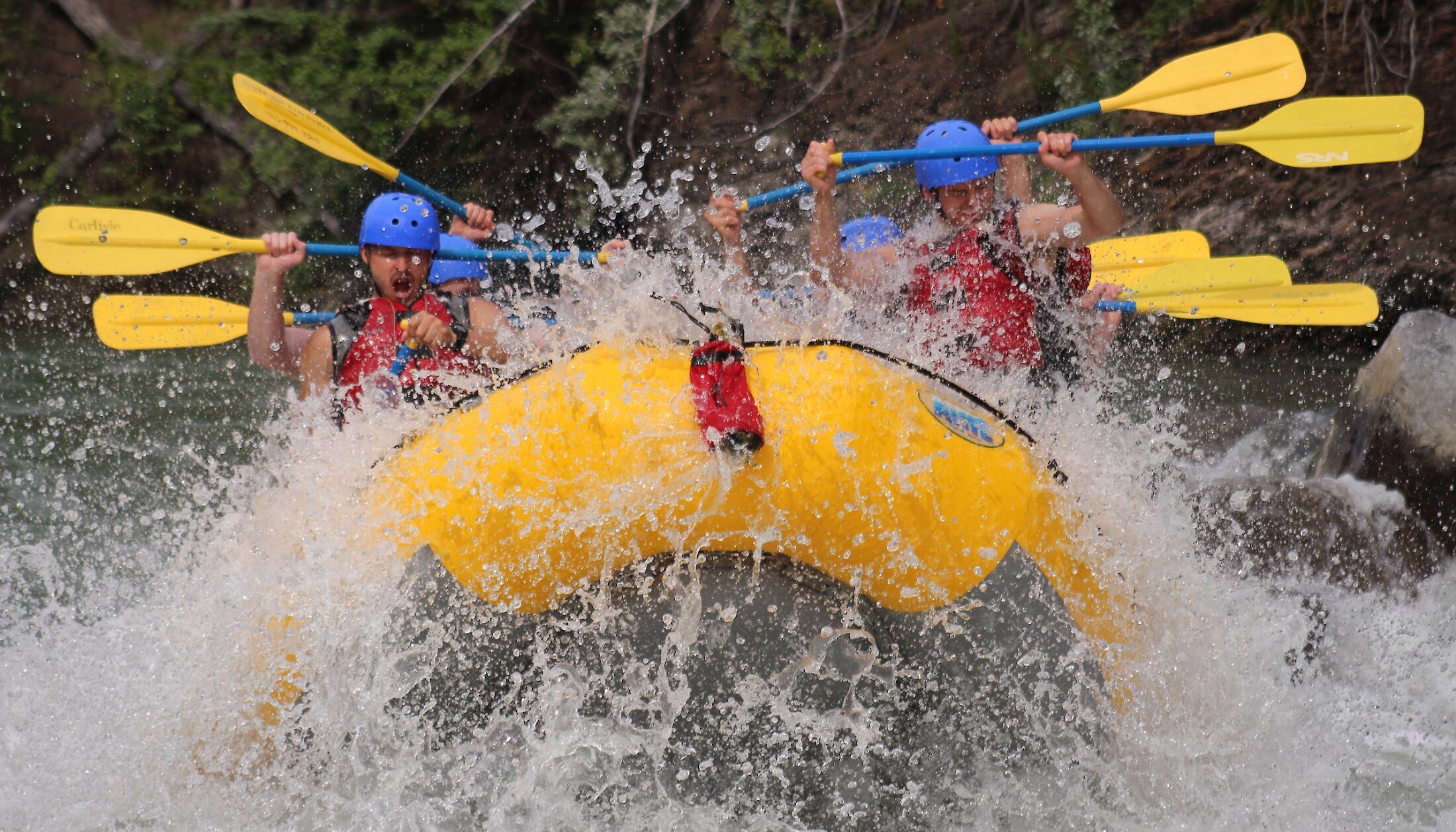 People in a raft bracing for a big wave on Kananaskis river
