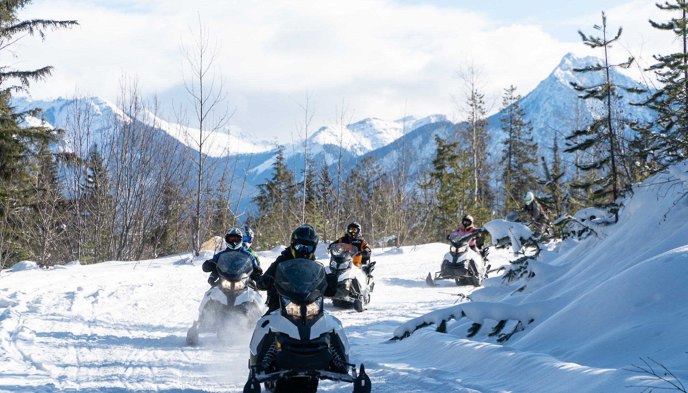 Snowmobilers following the mountain trail in Kicking Horse