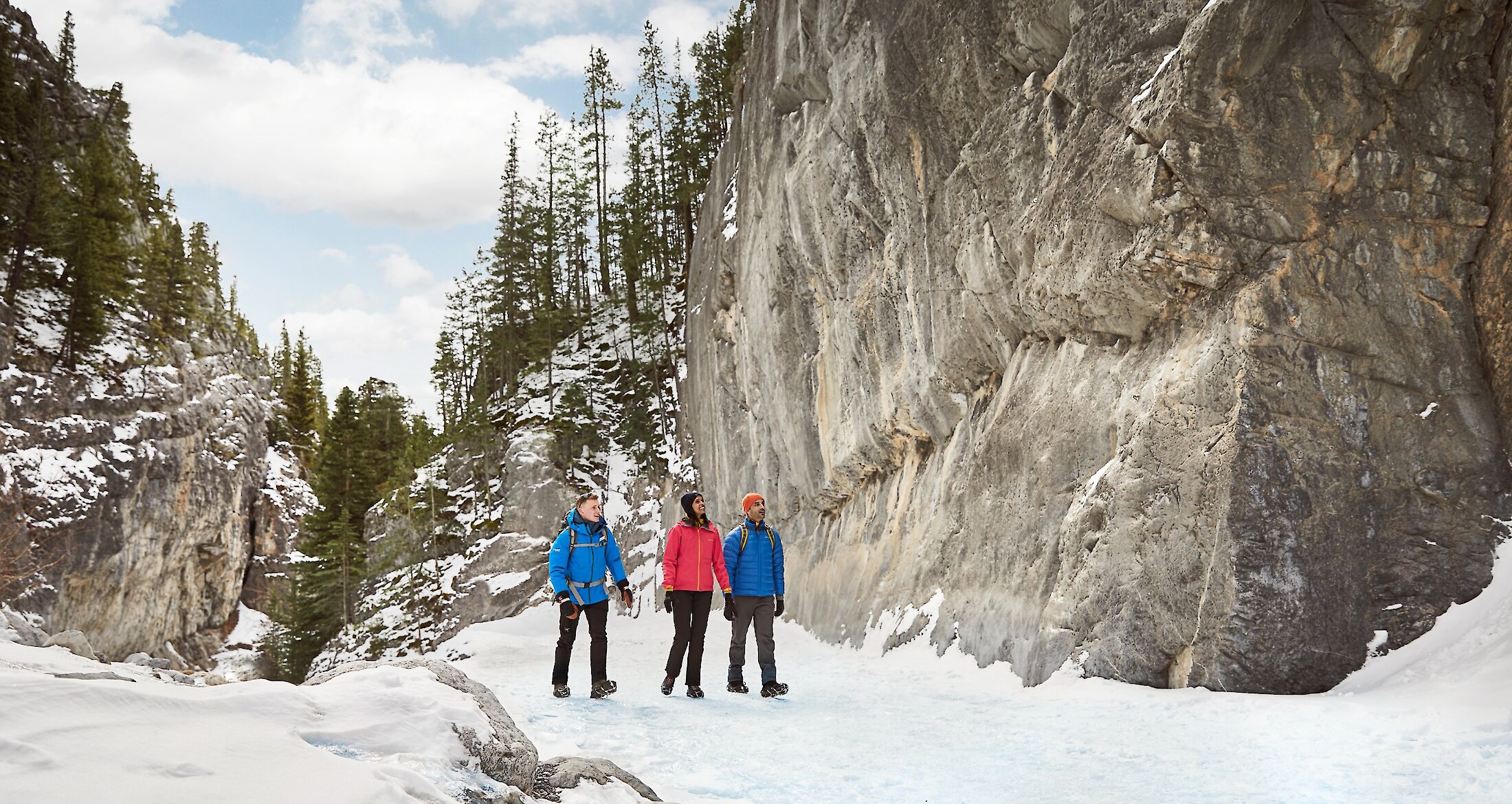 A group walking on a frozen river at Grotto Canyon