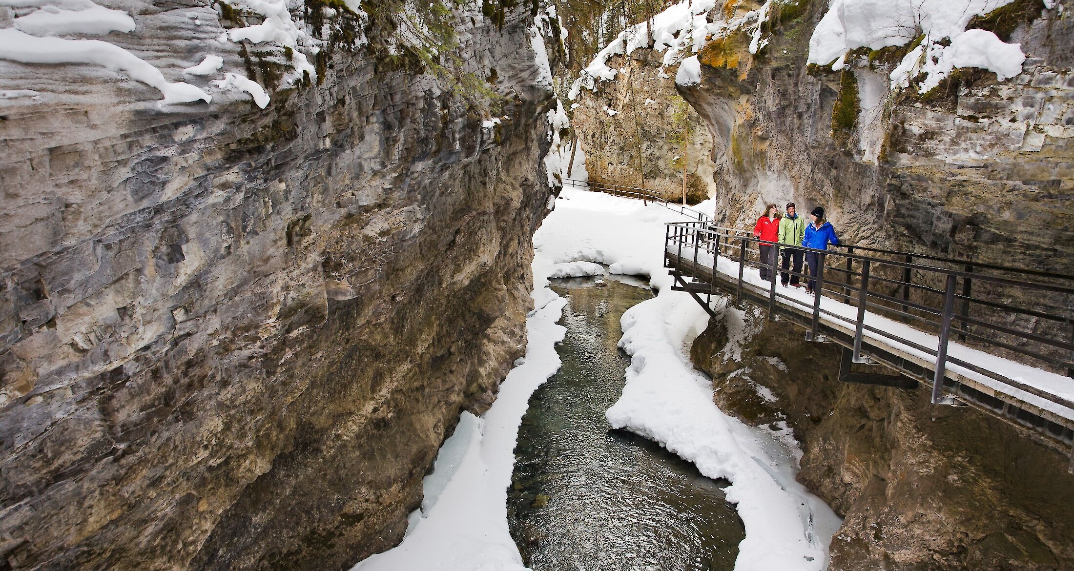 A group walking through the snowy Johnston Canyon in Banff