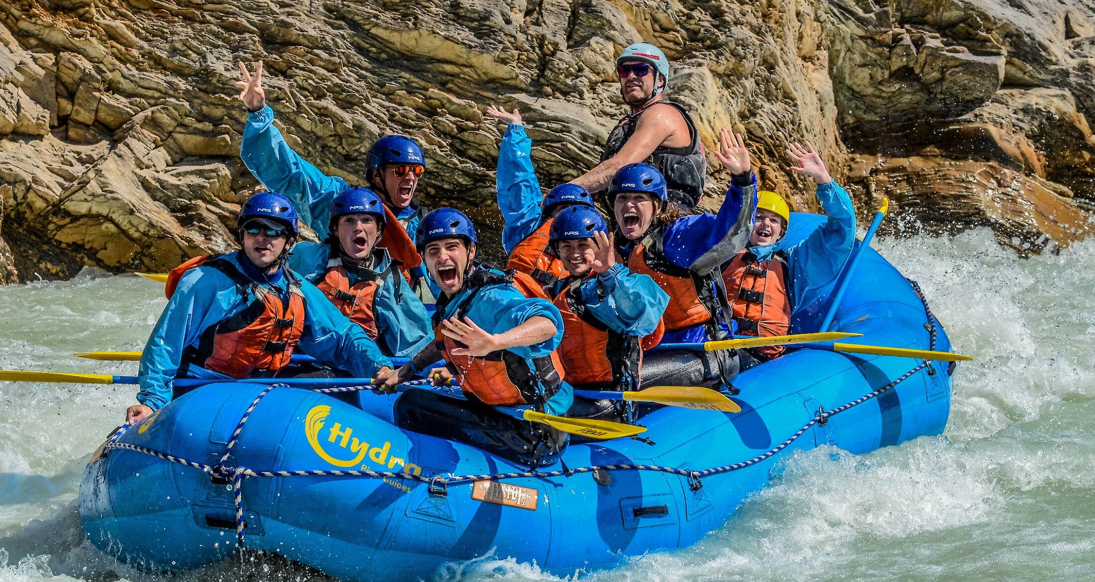 A group of people on a raft on the Kicking Horse River going through the rapids