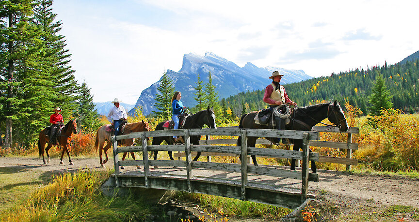 Horseback riders riding over a bridge in Banff National Park