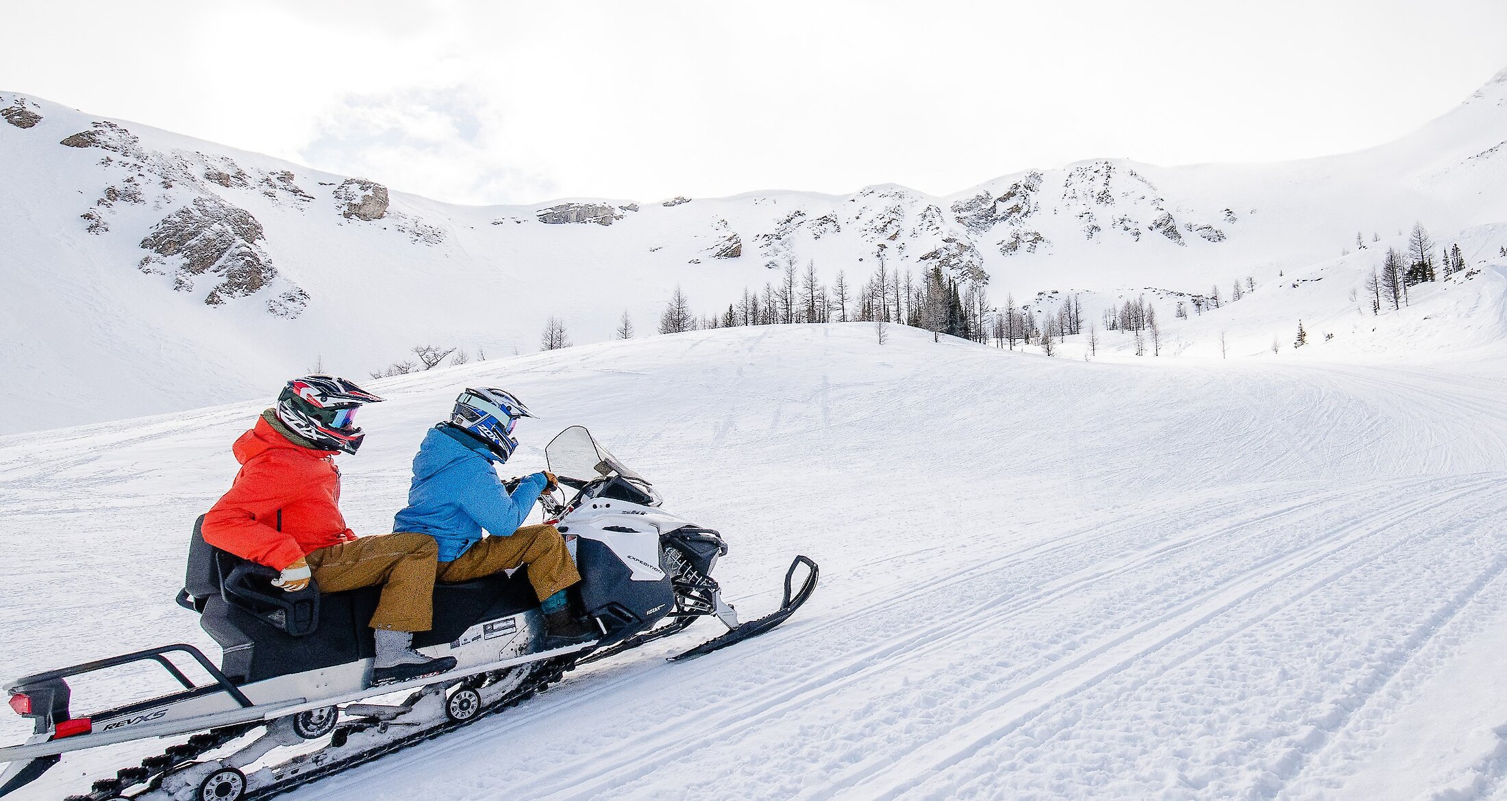 A couple on a snowmobile in the Paradise Basin in Panorama