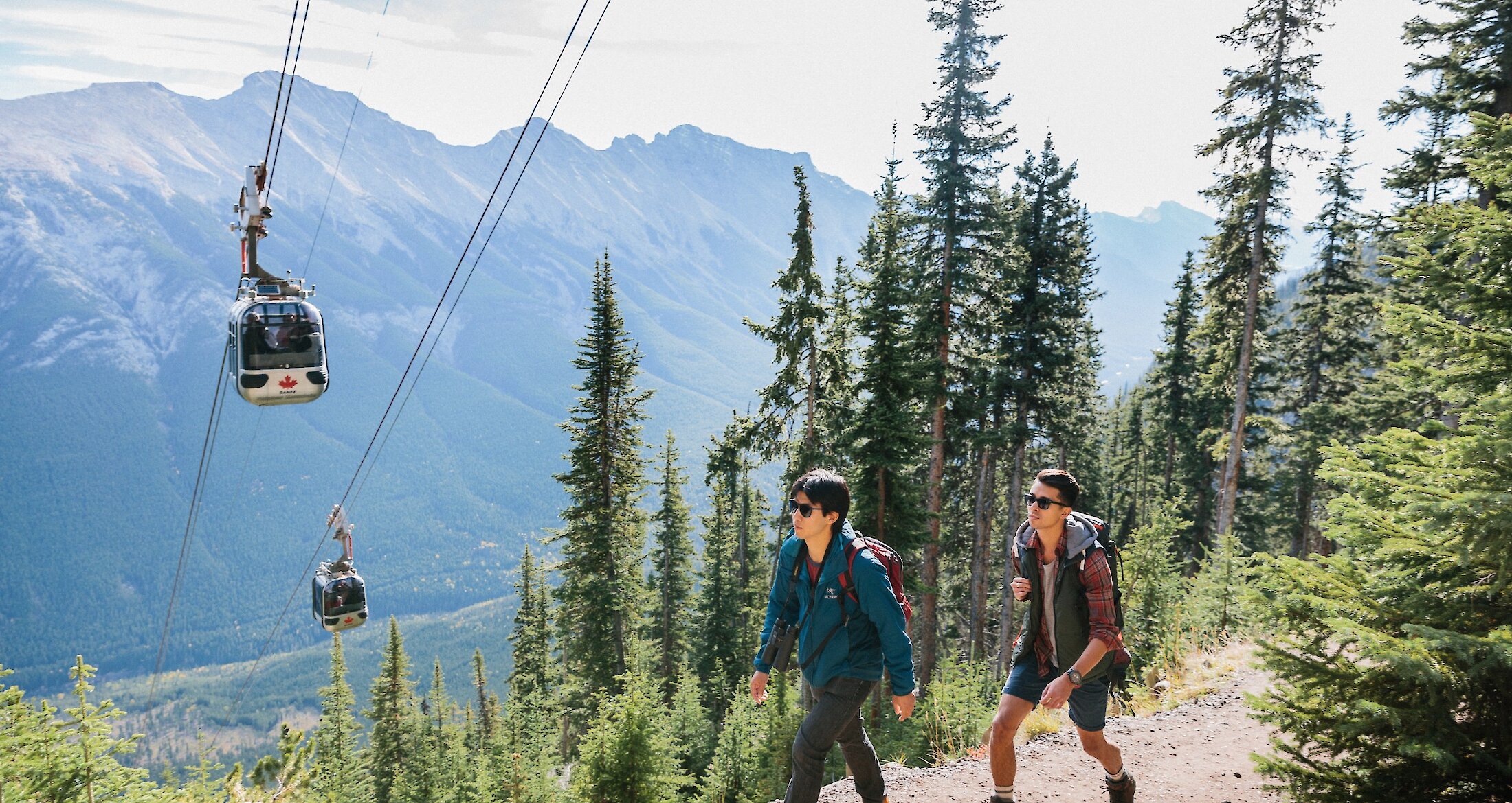 A couple hiking up sulphur mountain alongside the Banff Gondola