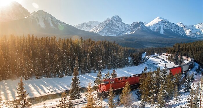 A train passing through Banff National Park at Christmas time in the snow