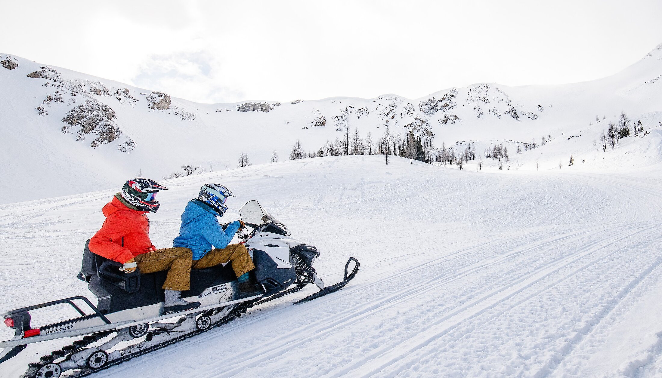 A couple riding a snowmobile at Panorama, BC