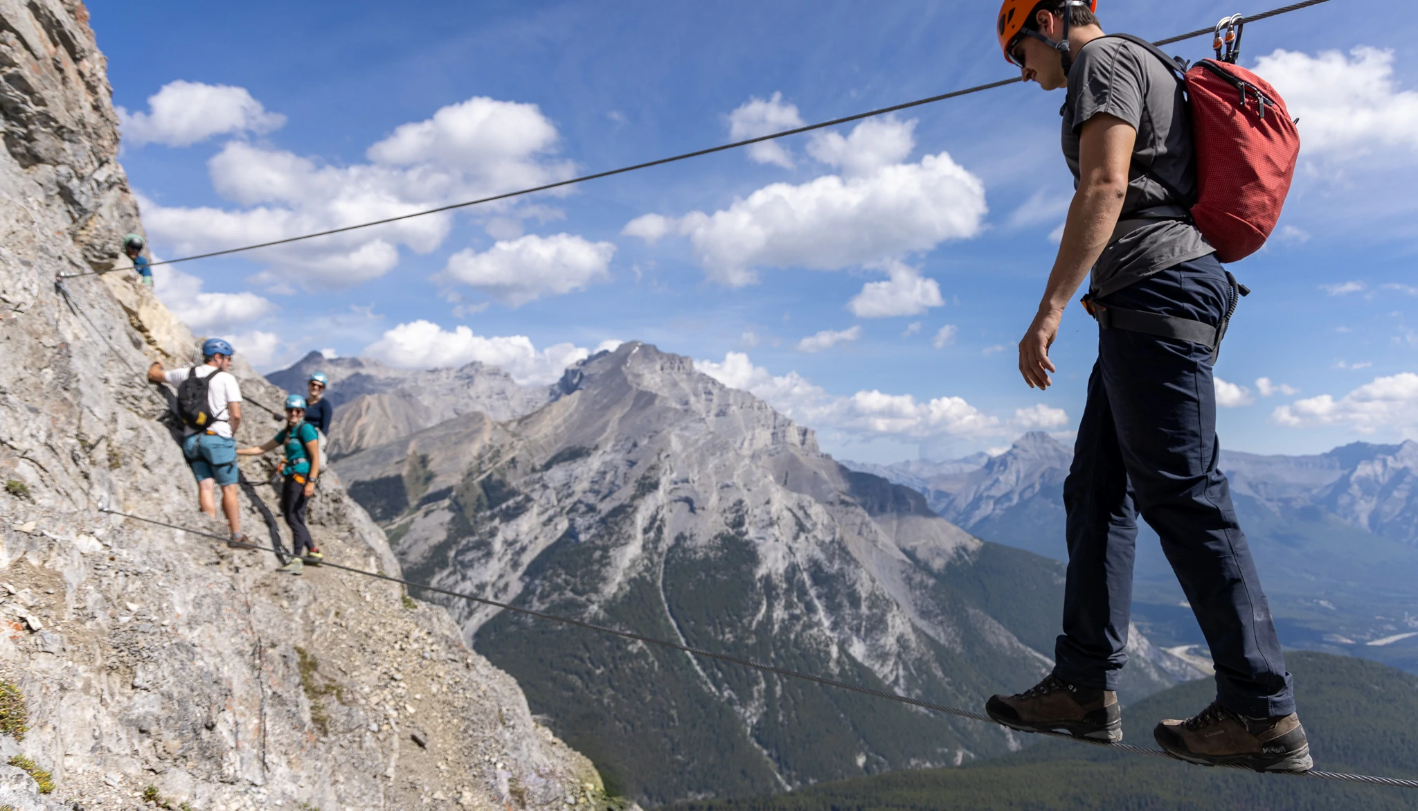 A climber walks along a tight rope on via ferrata
