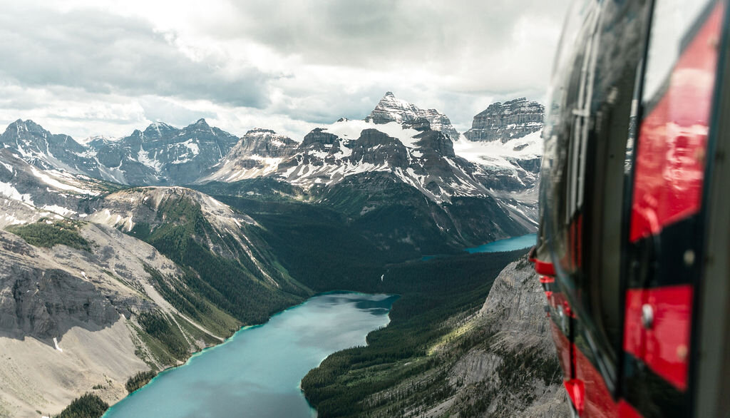 The view from a helicopter window looking over a lake in the Canadian Rockies