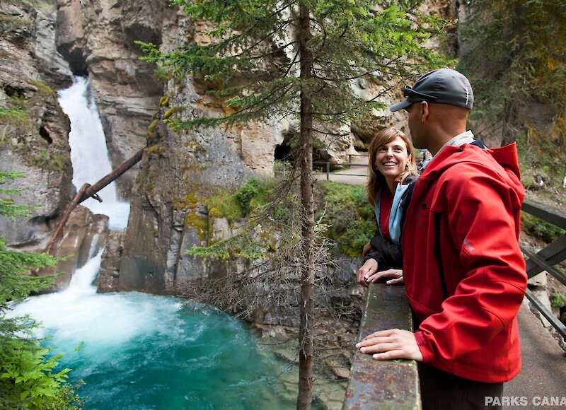 A couple enjoying the view at the lower falls of Johnston Canyon