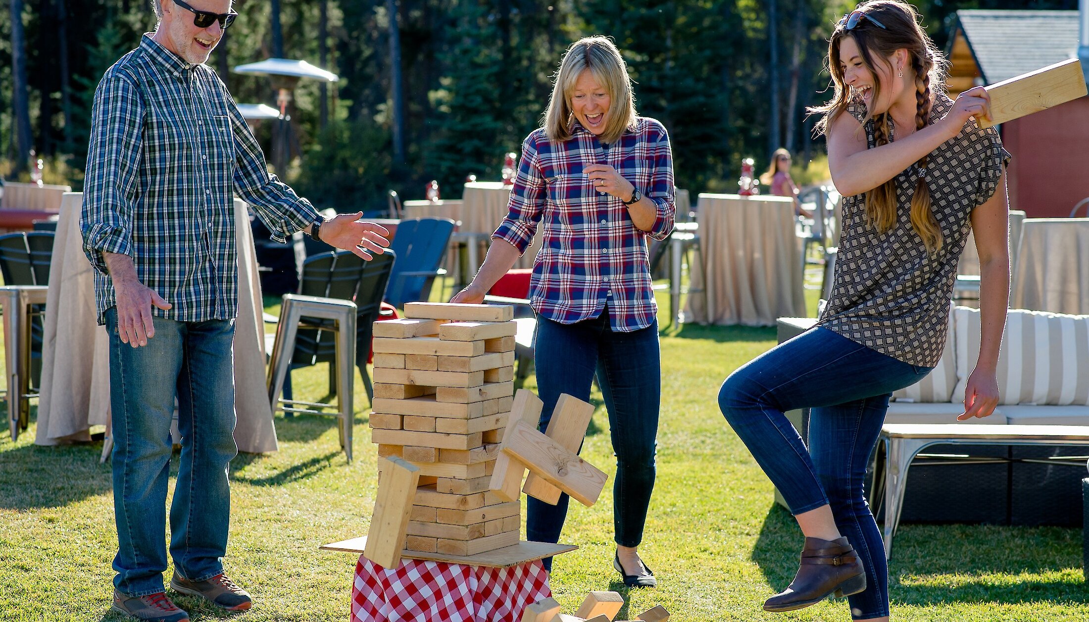 A group of friends playing jenga in the meadow at Banff Park Ranch