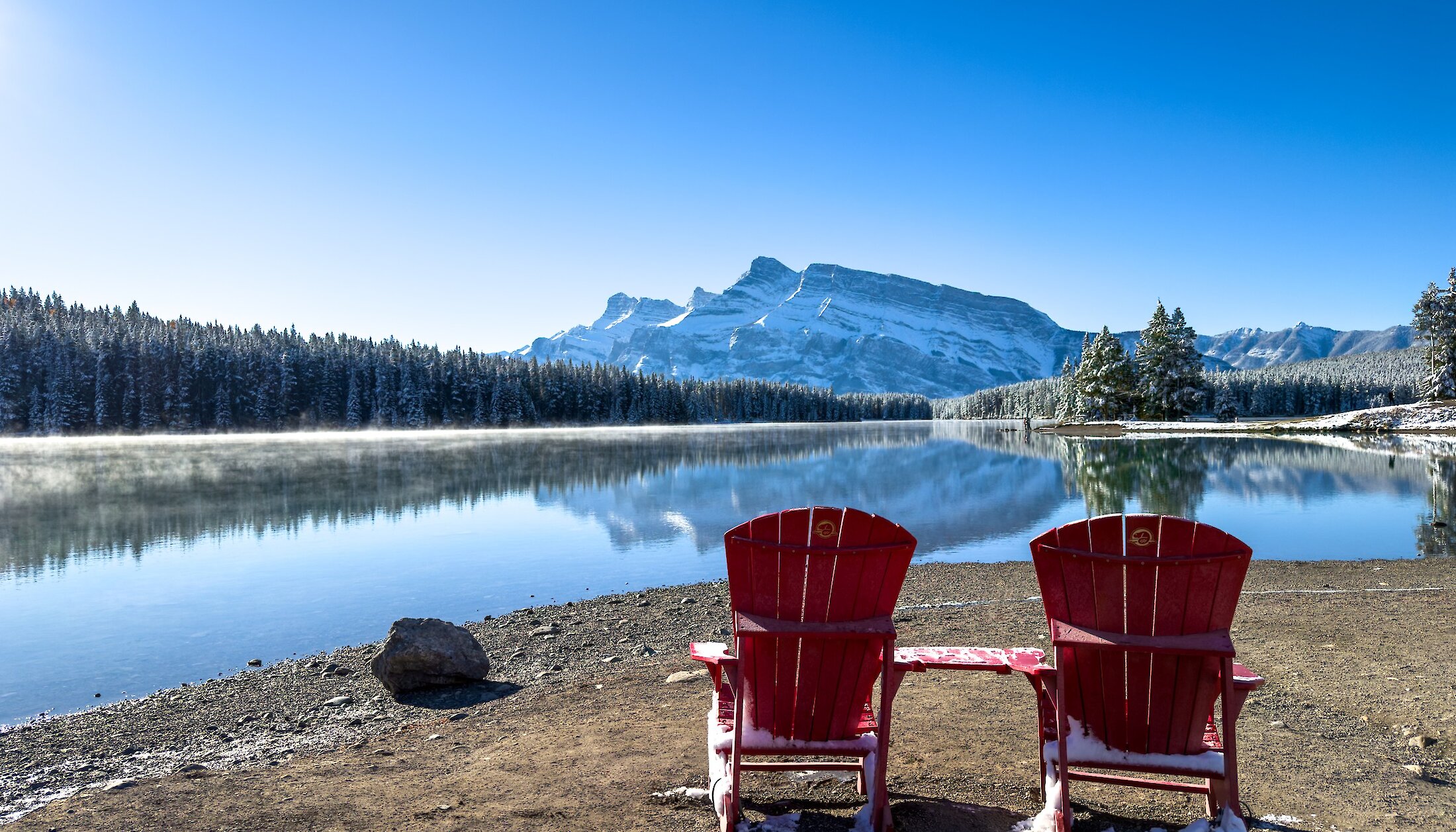 Two Parks Canada chairs on the shore of Two Jack Lake