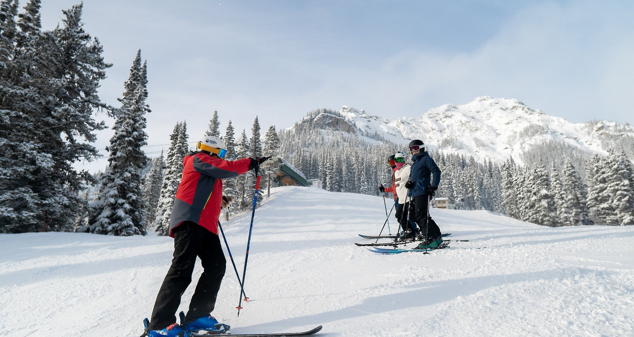 A ski Instructor providing advice to a group of adults in a ski lesson