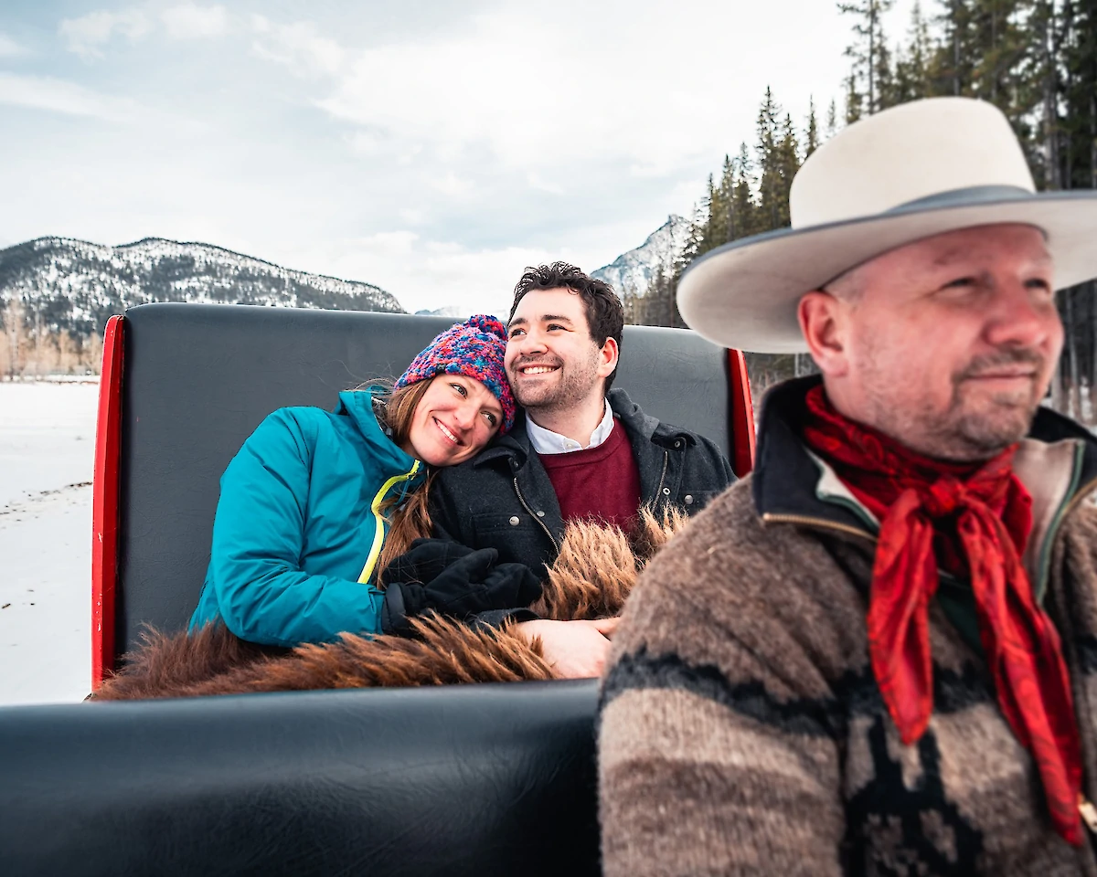 A couple enjoying the private sleigh ride in Banff Meadows