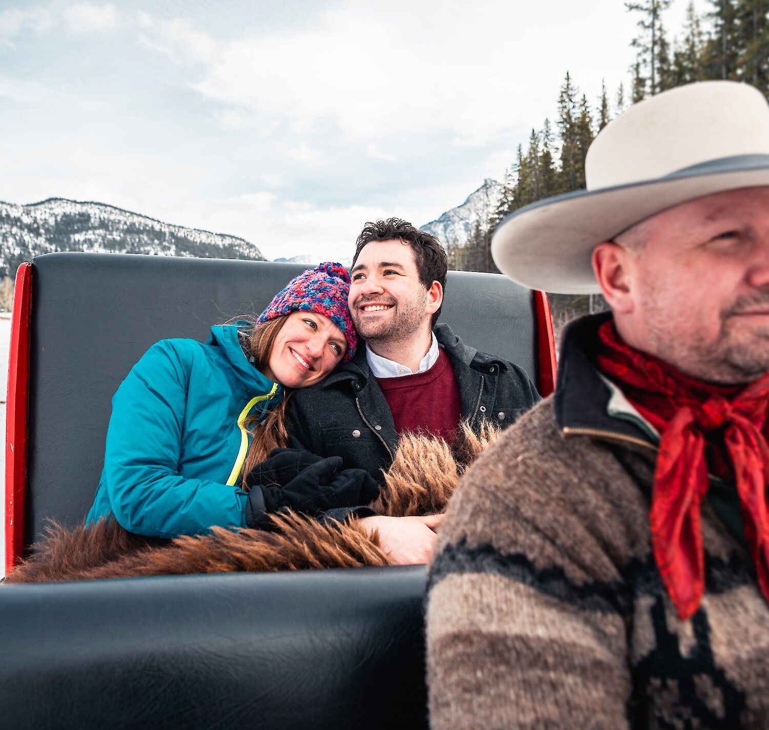 A couple enjoying the private sleigh ride in Banff Meadows