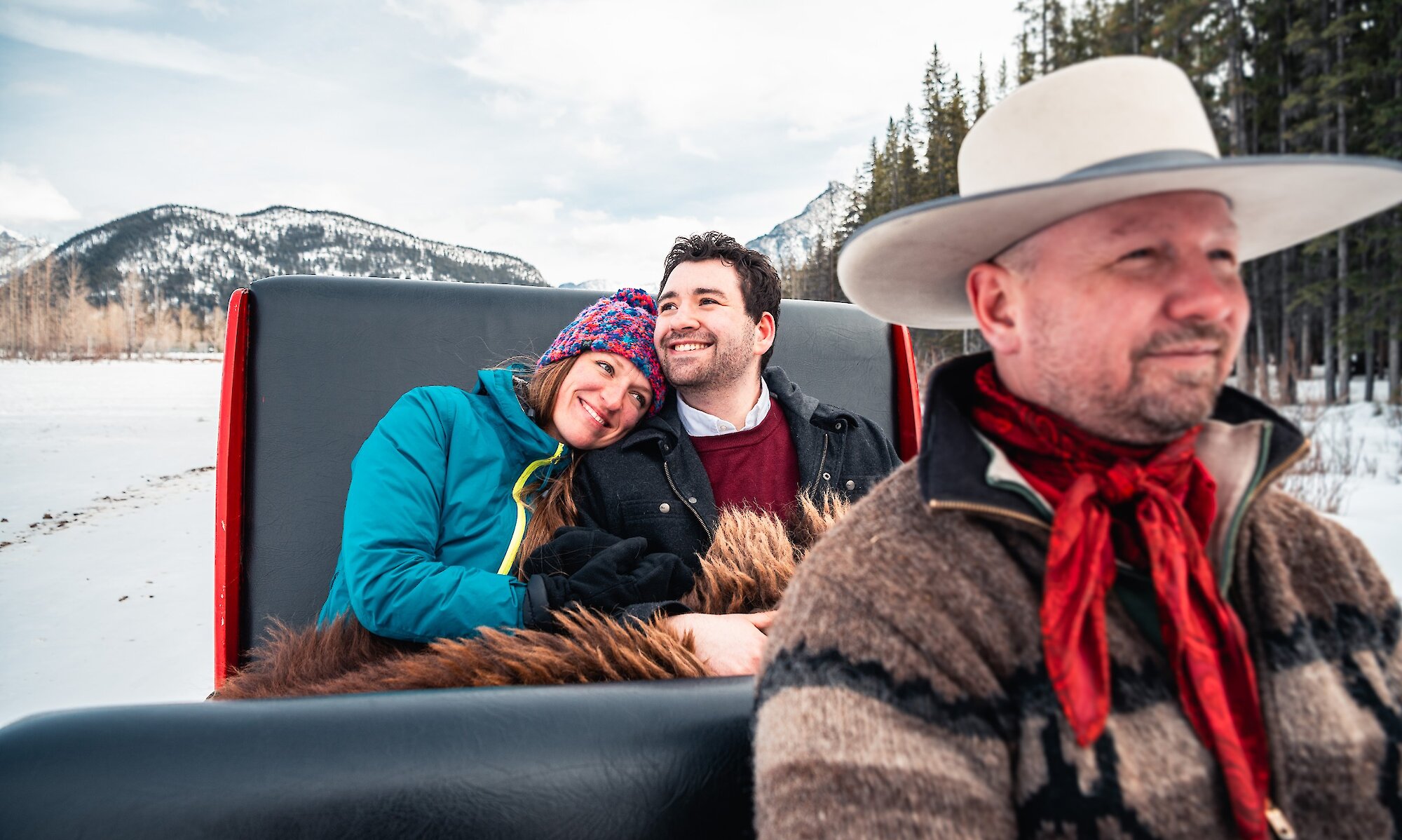 A couple enjoying the private sleigh ride in Banff Meadows