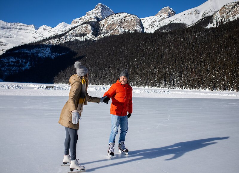 A couple ice skating on frozen Lake Louise