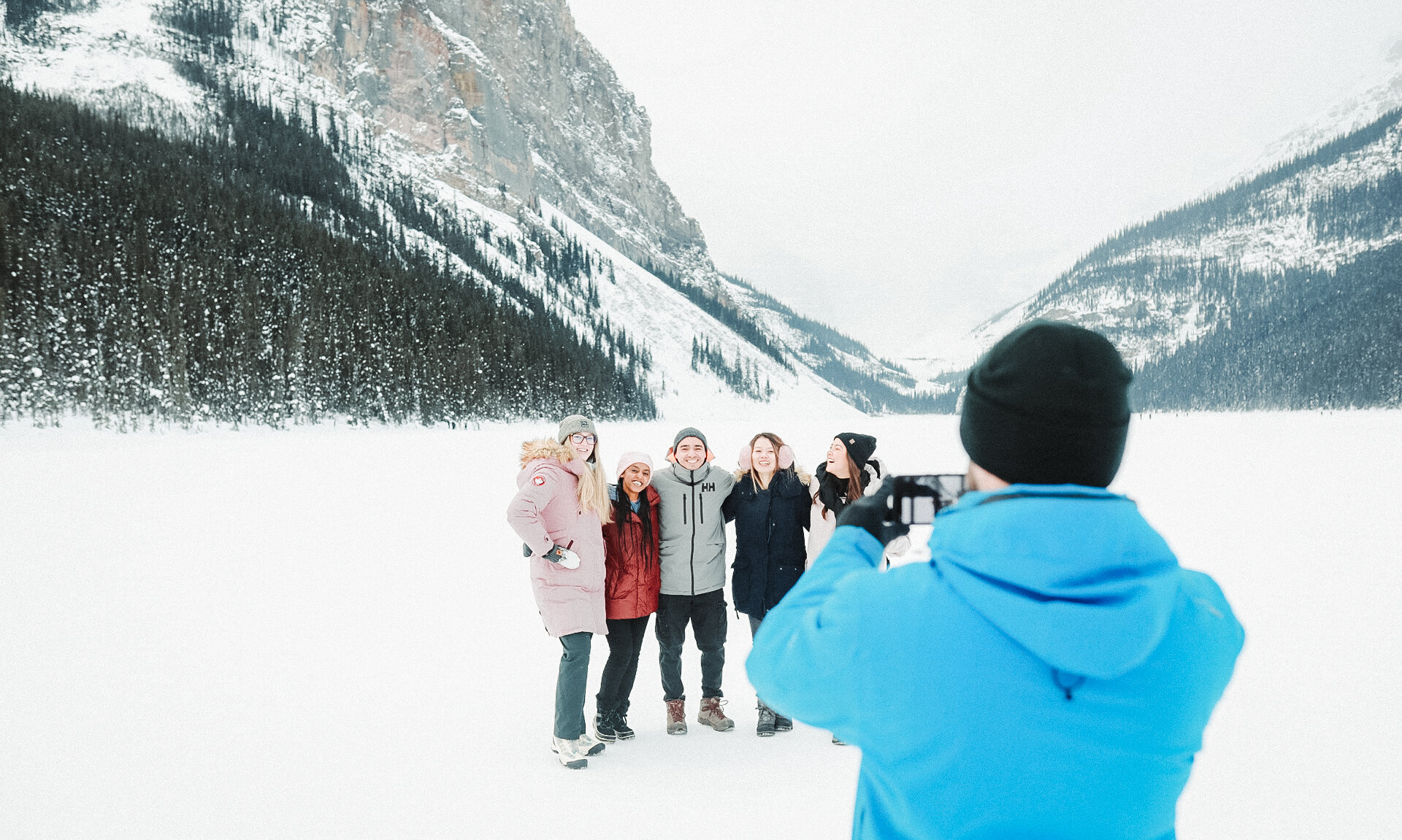 A guide taking a picture of a group of friends on Lake Louise