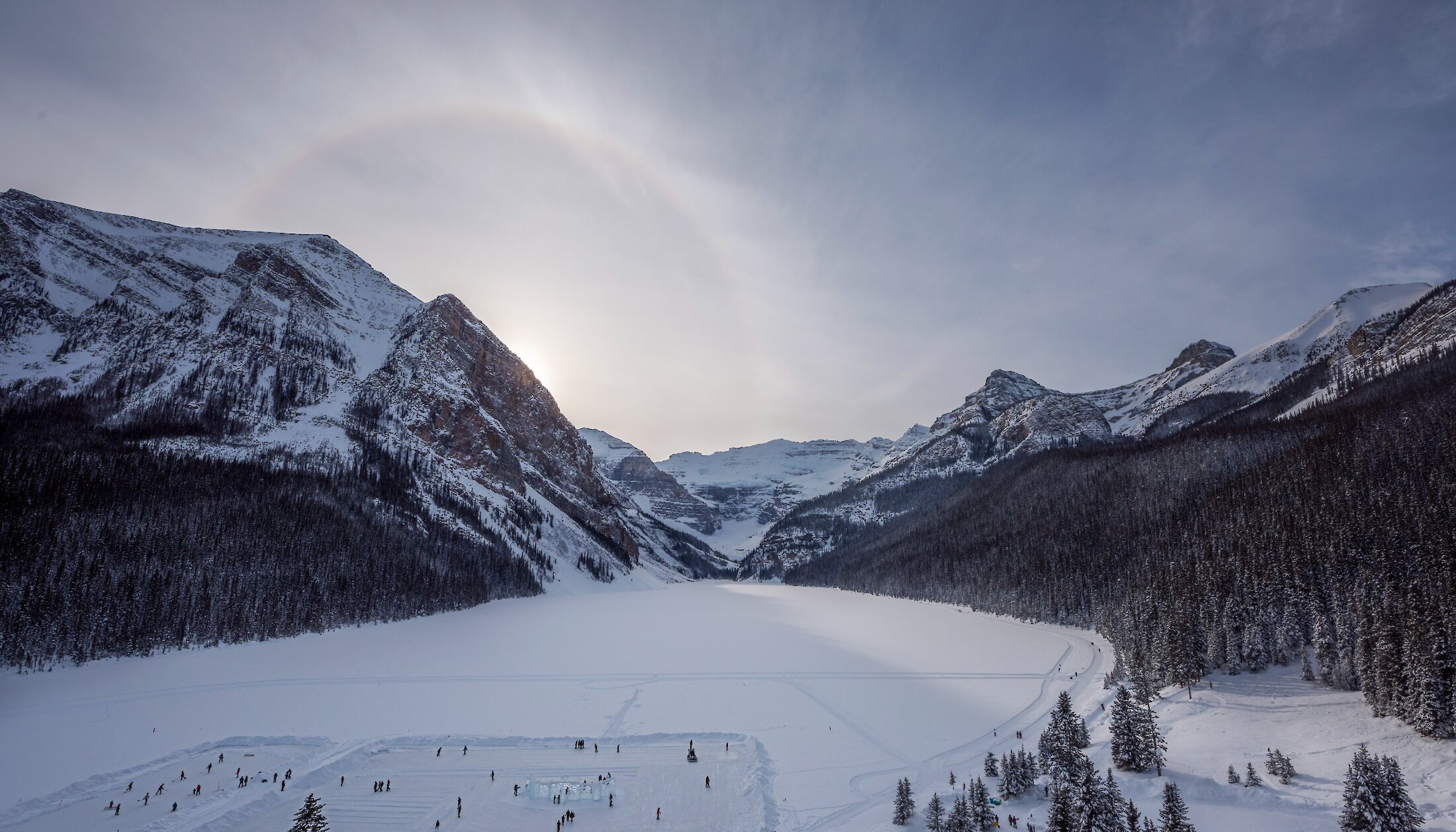 A view of a frozen Lake Louise including the lake, victoria glacier and ice rink
