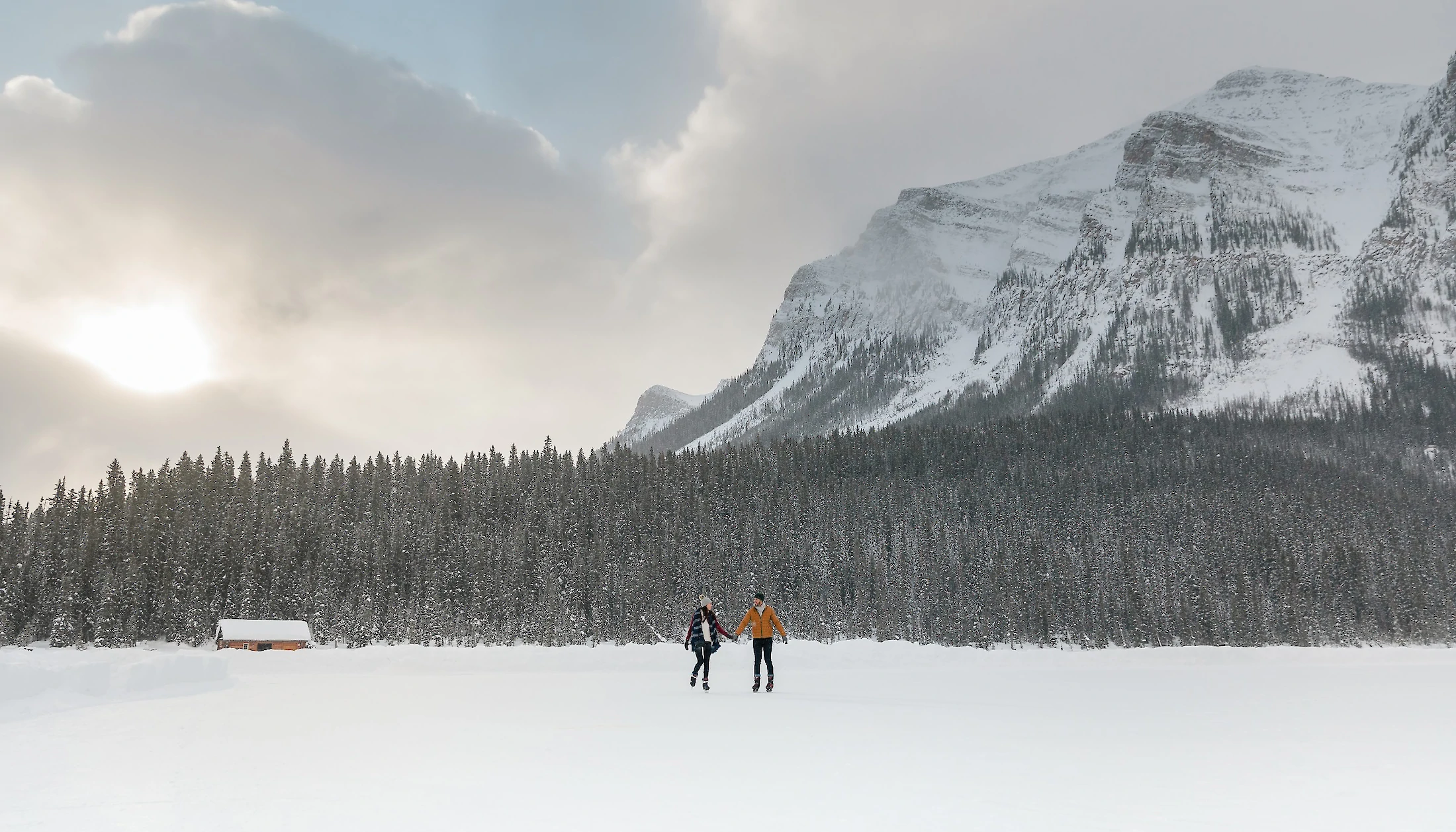 A couple ice skating on a frozen Lake Louise
