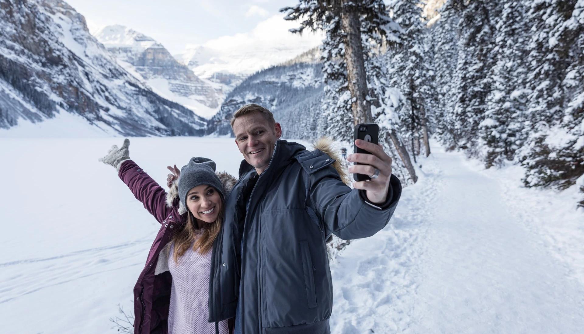 a couple at snowy Lake Louise enjoying the mountain air