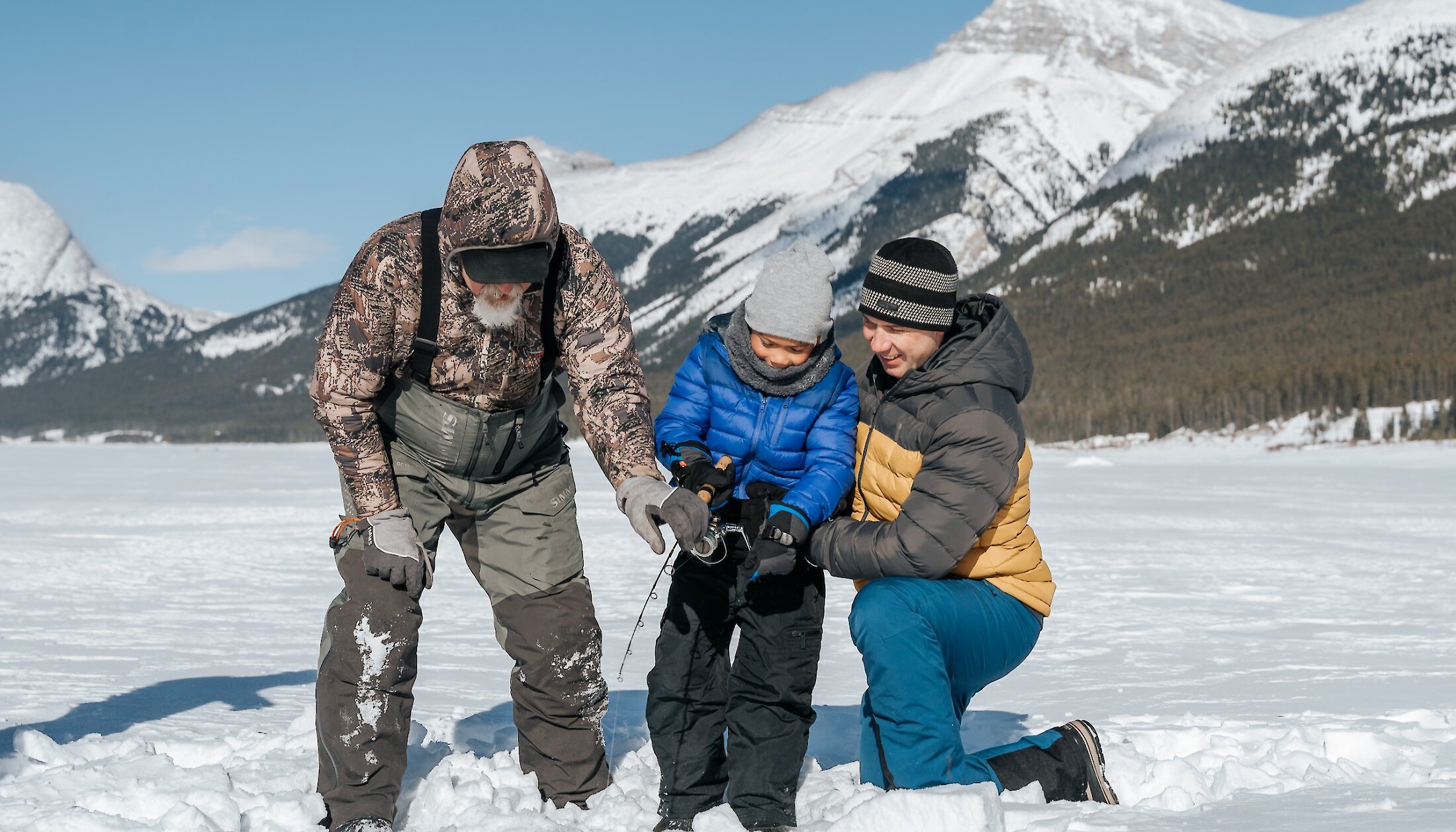 A family ice fishing on spray lakes on a guided tour