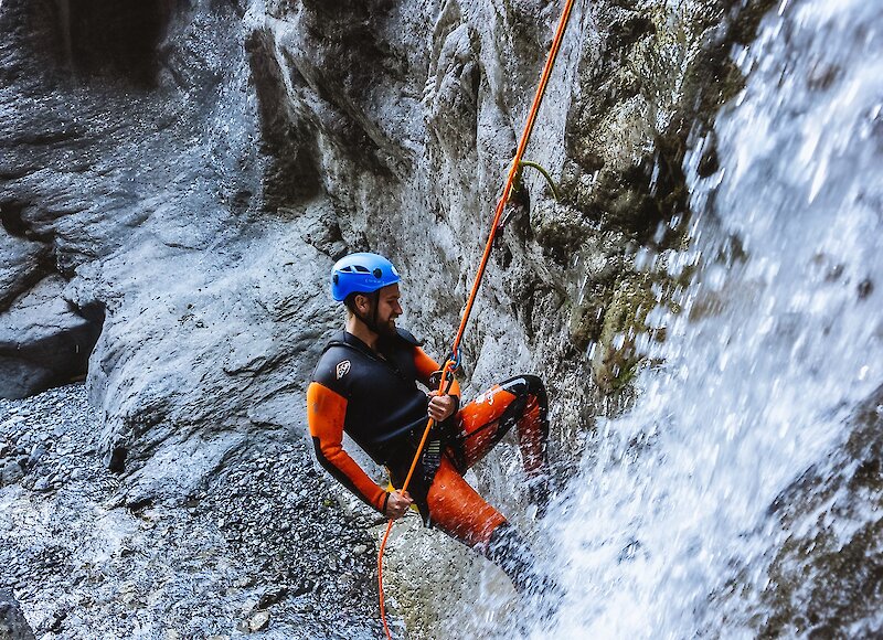 Guest rappelling down the canyon