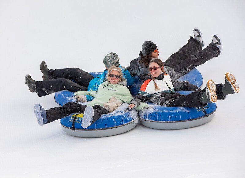 A group of friends snow tubing at Mount Norquay