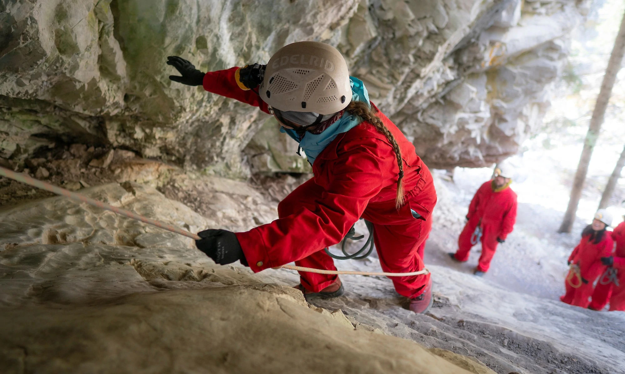 Climbing up to the cave entrance using a rope