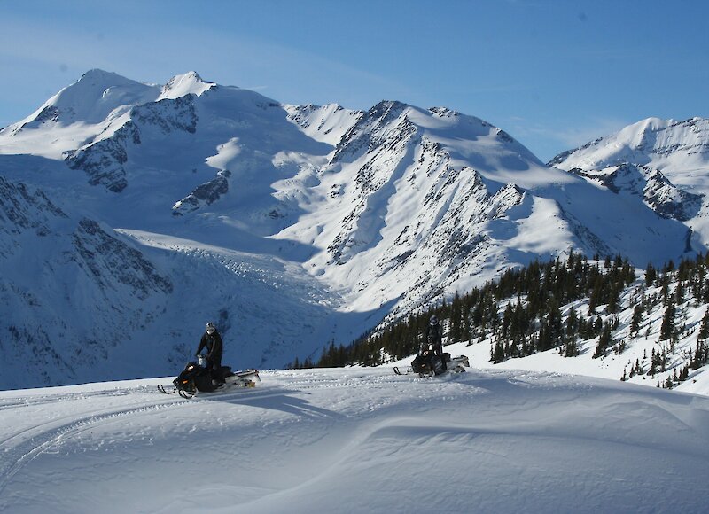 A person snowmobiling with mountain views