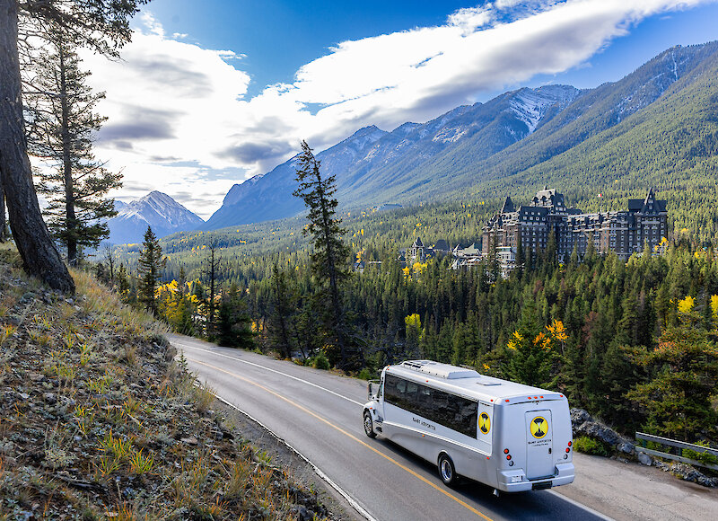 airport shuttle bus travelling past the Fairmont Banff Springs