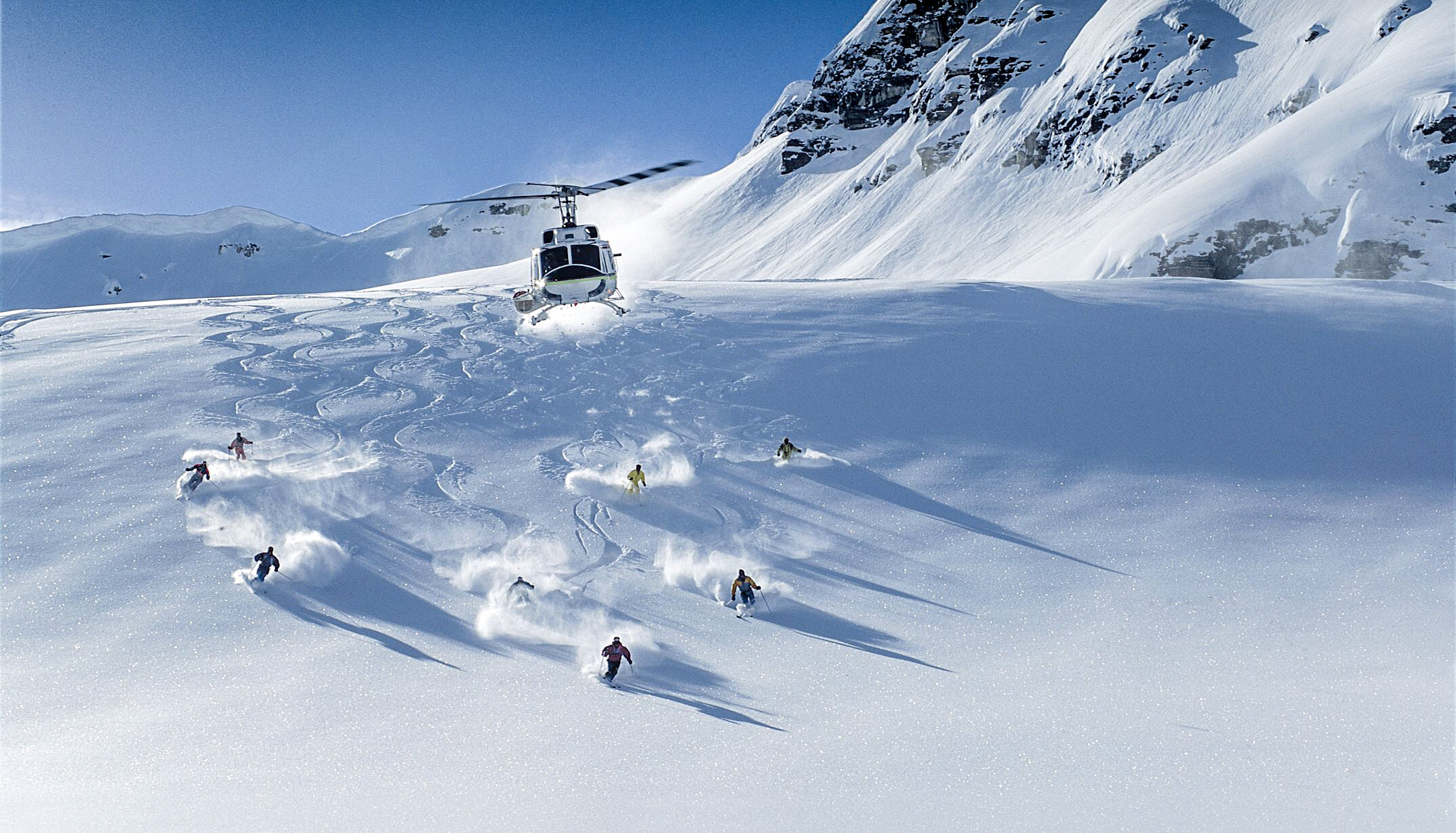 Group  of heliskiers shredding down the mountain