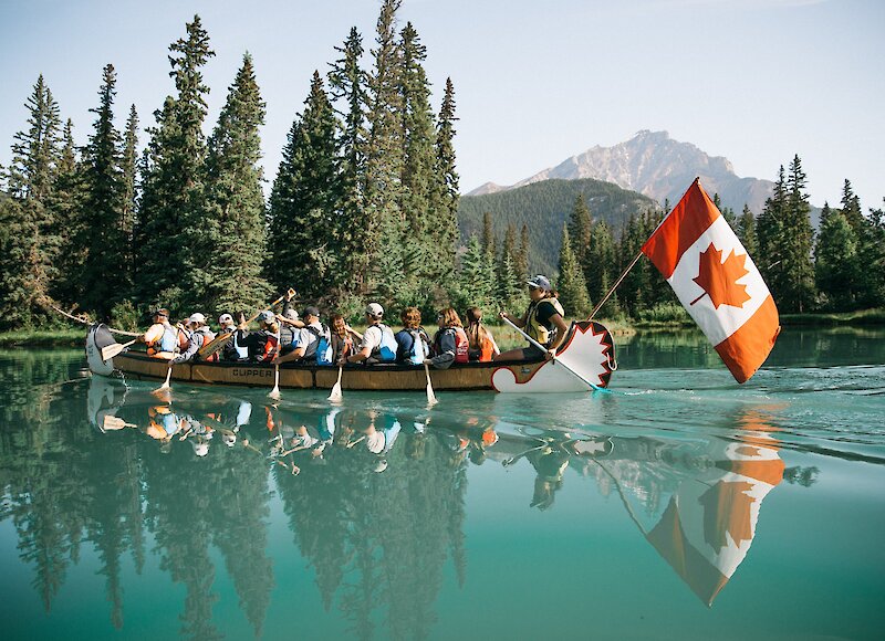 A Big Canoe Tour paddling on the turquoise waters of the Bow River in Banff