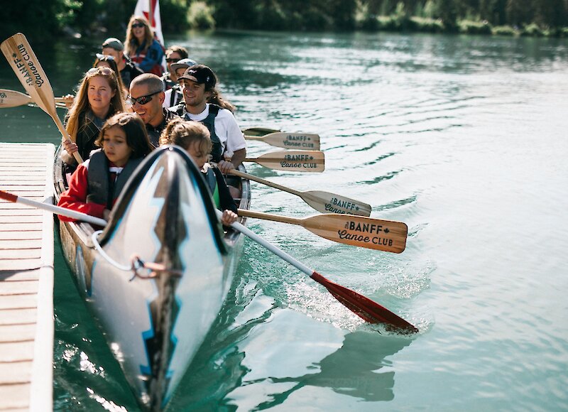 Guests at the docks of the Banff Canoe Club ready to set out on their Big Canoe tour on the Bow River